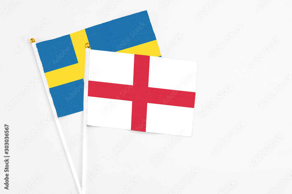 England and Sweden stick flags on white background. High quality fabric, miniature national flag. Peaceful global concept.White floor for copy space.