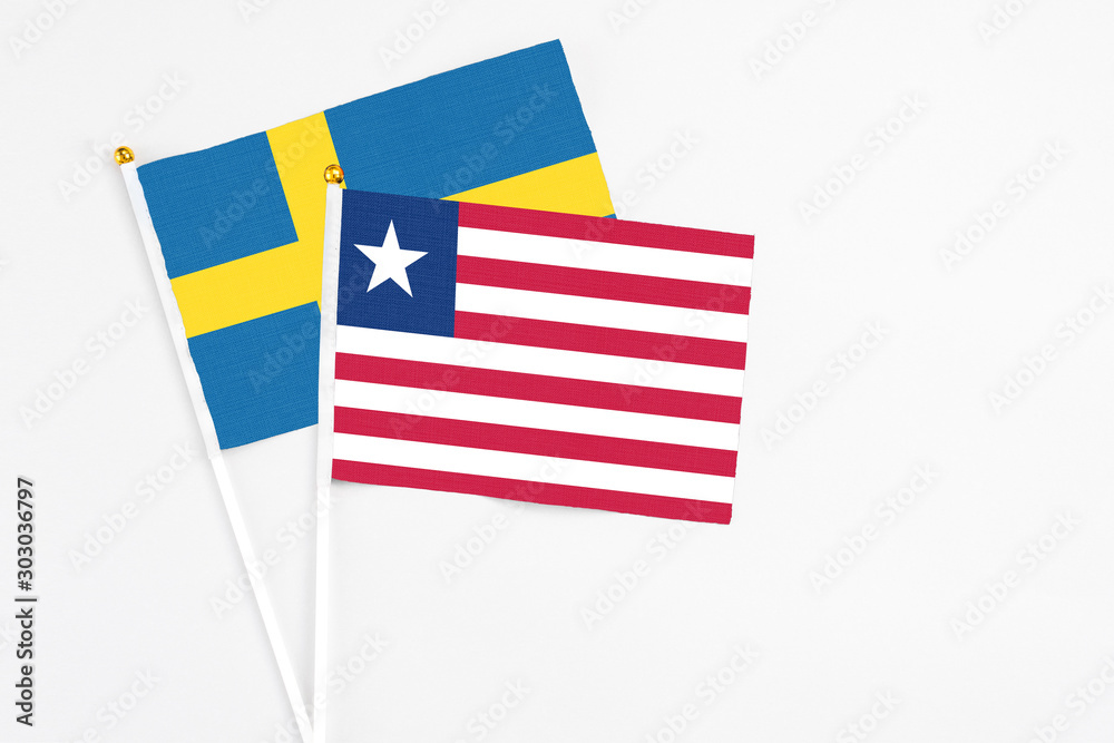 Liberia and Sweden stick flags on white background. High quality fabric, miniature national flag. Peaceful global concept.White floor for copy space. Liberia and Sweden stick flags on white background. High quality fabric, miniature national flag. Peaceful global concept.White floor for copy space.