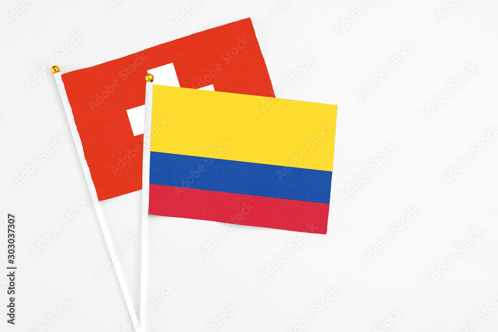 Colombia and Switzerland stick flags on white background. High quality fabric, miniature national flag. Peaceful global concept.White floor for copy space. Colombia and Switzerland stick flags on white background. High quality fabric, miniature national flag. Peaceful global concept.White floor for copy space.