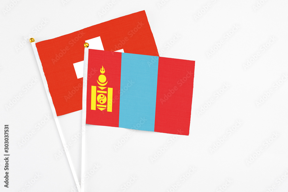 Mongolia and Switzerland stick flags on white background. High quality fabric, miniature national flag. Peaceful global concept.White floor for copy space.