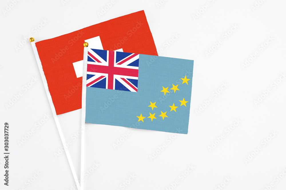 Tuvalu and Switzerland stick flags on white background. High quality fabric, miniature national flag. Peaceful global concept.White floor for copy space. Tuvalu and Switzerland stick flags on white background. High quality fabric, miniature national flag. Peaceful global concept.White floor for copy space.