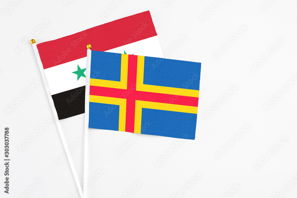 Aland Islands and Syria stick flags on white background. High quality fabric, miniature national flag. Peaceful global concept.White floor for copy space. Aland Islands and Syria stick flags on white background. High quality fabric, miniature national flag. Peaceful global concept.White floor for copy space.