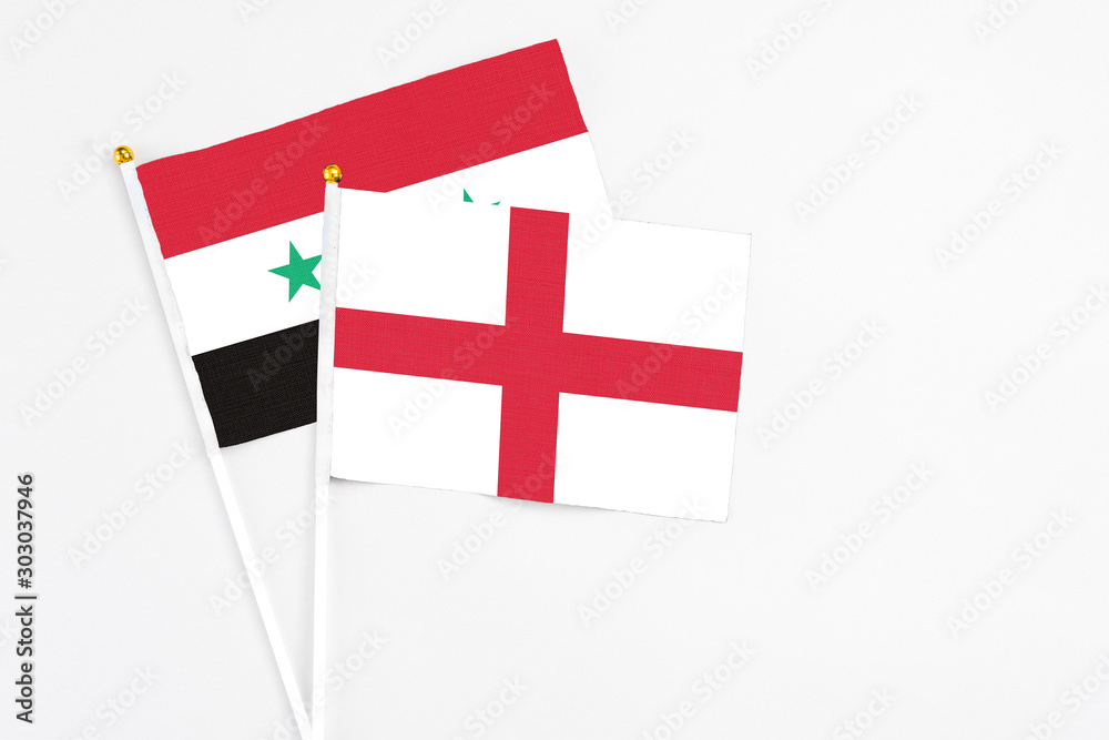 England and Syria stick flags on white background. High quality fabric, miniature national flag. Peaceful global concept.White floor for copy space.