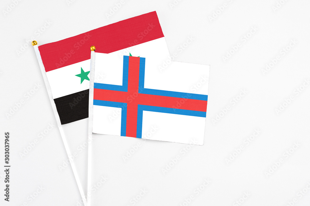 Faroe Islands and Syria stick flags on white background. High quality fabric, miniature national flag. Peaceful global concept.White floor for copy space.
