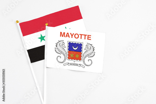Mayotte and Syria stick flags on white background. High quality fabric, miniature national flag. Peaceful global concept.White floor for copy space.