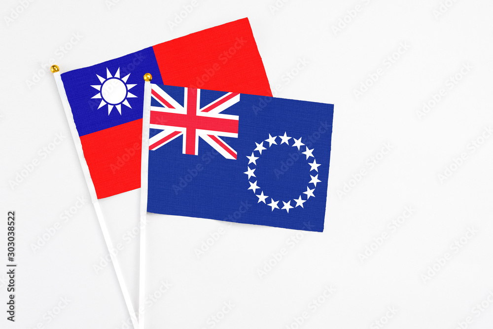 Fototapeta premium Cook Islands and Taiwan stick flags on white background. High quality fabric, miniature national flag. Peaceful global concept.White floor for copy space.