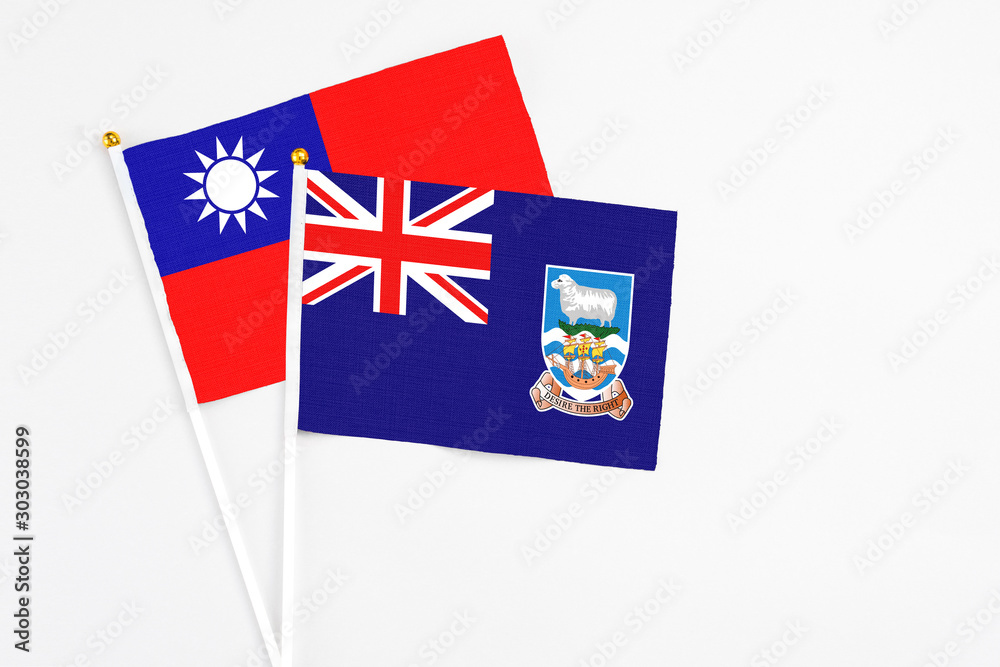Fototapeta premium Falkland Islands and Taiwan stick flags on white background. High quality fabric, miniature national flag. Peaceful global concept.White floor for copy space.