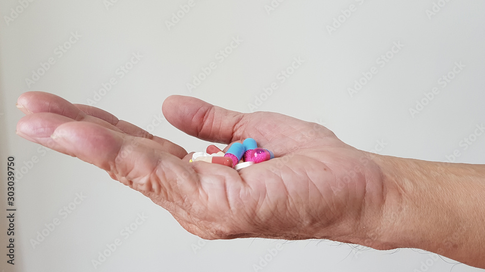 Hand with Polypharmacy, the used of multiple medications by a patient with many chronic disease. This lead to poor treatment effectiveness, harmful and adverse drug reaction. Elderly care concept Hand with Polypharmacy, the used of multiple medications by a patient with many chronic disease. This lead to poor treatment effectiveness, harmful and adverse drug reaction. Elderly care concept