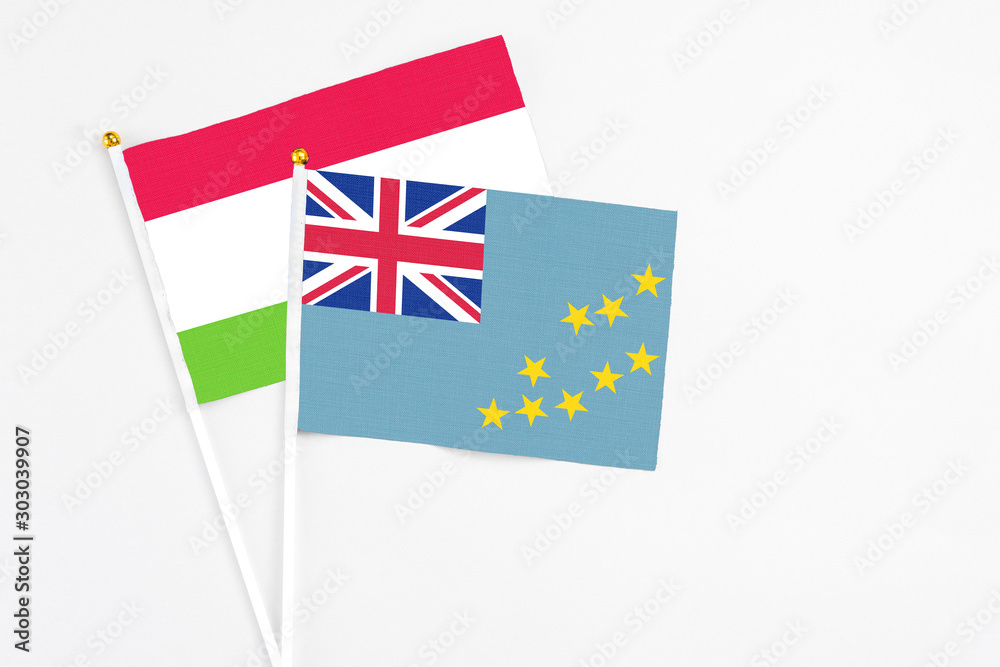 Fototapeta premium Tuvalu and Tajikistan stick flags on white background. High quality fabric, miniature national flag. Peaceful global concept.White floor for copy space.