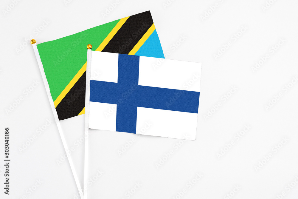 Finland and Tanzania stick flags on white background. High quality fabric, miniature national flag. Peaceful global concept.White floor for copy space. Finland and Tanzania stick flags on white background. High quality fabric, miniature national flag. Peaceful global concept.White floor for copy space.