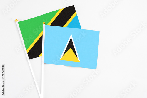 Free Download Saint Lucia and Tanzania stick flags on white background. High quality fabric, miniature national flag. Peaceful global concept.White floor for copy space. - GFXLoad