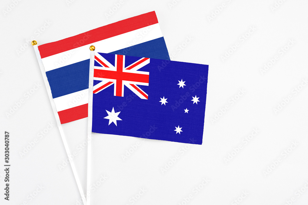 Fototapeta premium Australia and Thailand stick flags on white background. High quality fabric, miniature national flag. Peaceful global concept.White floor for copy space.