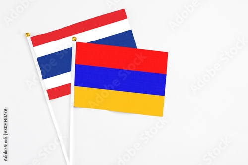 Armenia and Thailand stick flags on white background. High quality fabric, miniature national flag. Peaceful global concept.White floor for copy space.