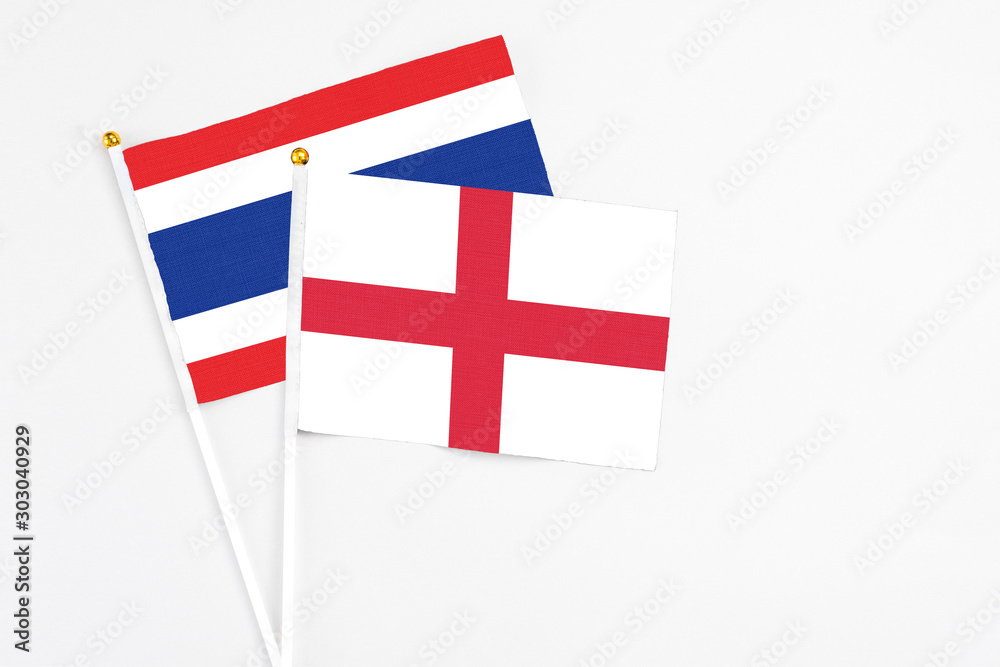 England and Thailand stick flags on white background. High quality fabric, miniature national flag. Peaceful global concept.White floor for copy space.