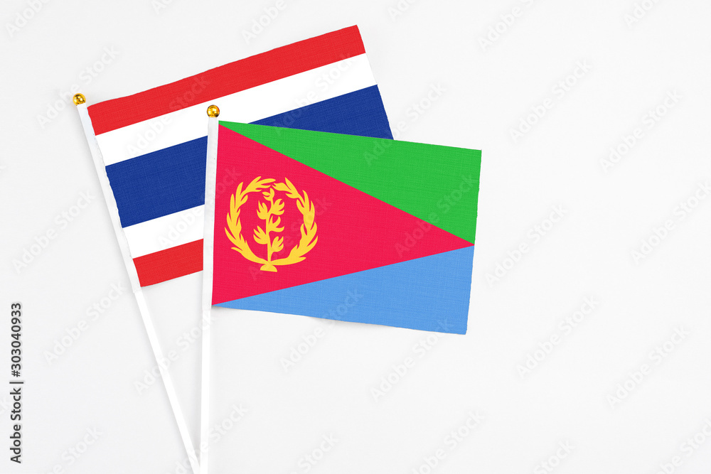 Naklejka premium Eritrea and Thailand stick flags on white background. High quality fabric, miniature national flag. Peaceful global concept.White floor for copy space.