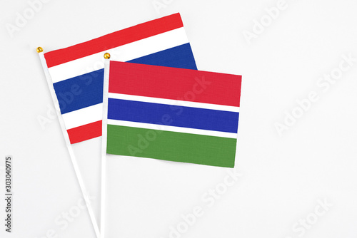 Gambia and Thailand stick flags on white background. High quality fabric  miniature national flag. Peaceful global concept.White floor for copy space.