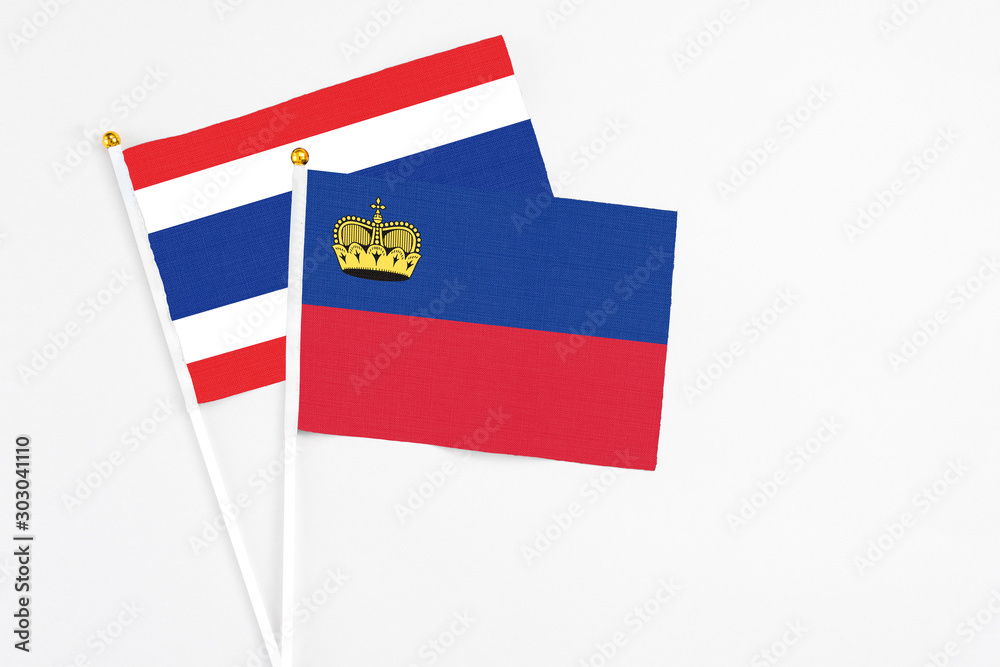 Liechtenstein and Thailand stick flags on white background. High quality fabric, miniature national flag. Peaceful global concept.White floor for copy space. Liechtenstein and Thailand stick flags on white background. High quality fabric, miniature national flag. Peaceful global concept.White floor for copy space.