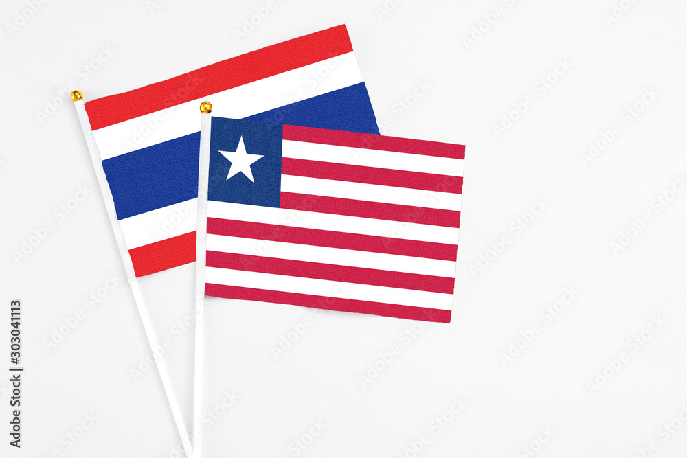 Liberia and Thailand stick flags on white background. High quality fabric, miniature national flag. Peaceful global concept.White floor for copy space. Liberia and Thailand stick flags on white background. High quality fabric, miniature national flag. Peaceful global concept.White floor for copy space.