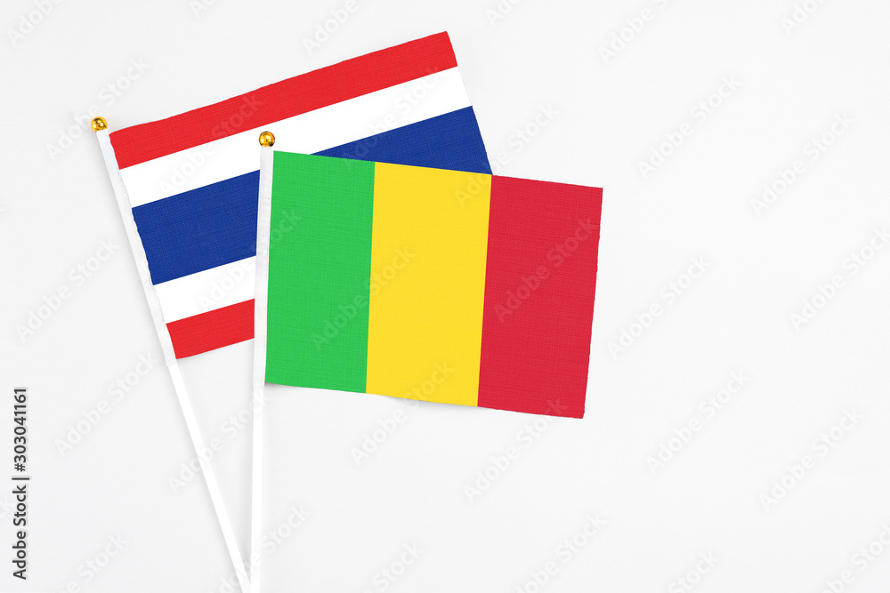 Mali and Thailand stick flags on white background. High quality fabric, miniature national flag. Peaceful global concept.White floor for copy space. Mali and Thailand stick flags on white background. High quality fabric, miniature national flag. Peaceful global concept.White floor for copy space.