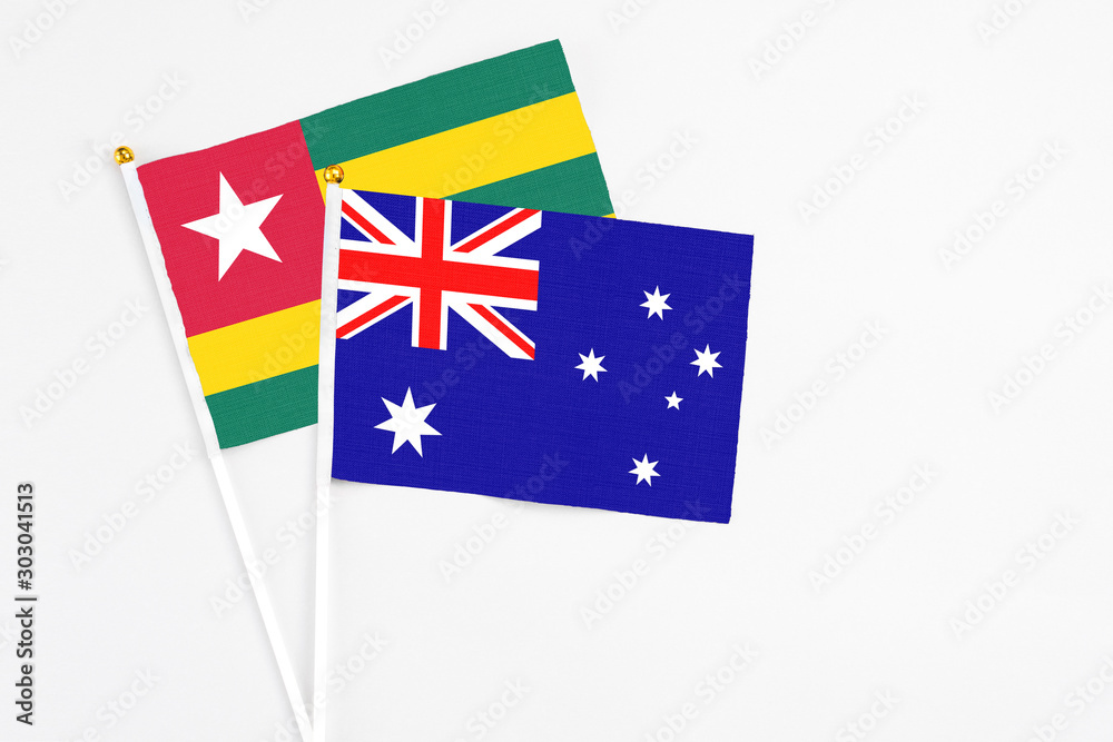 Fototapeta premium Australia and Togo stick flags on white background. High quality fabric, miniature national flag. Peaceful global concept.White floor for copy space.