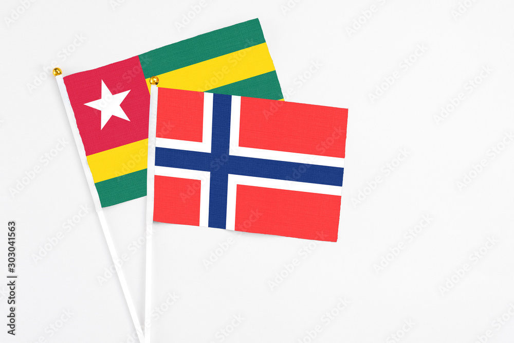 Bouvet Islands and Togo stick flags on white background. High quality fabric, miniature national flag. Peaceful global concept.White floor for copy space.