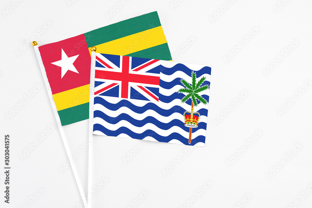 Fototapeta premium British Indian Ocean Territory and Togo stick flags on white background. High quality fabric, miniature national flag. Peaceful global concept.White floor for copy space.