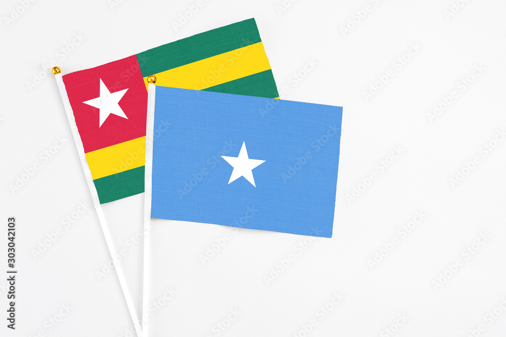 Somalia and Togo stick flags on white background. High quality fabric, miniature national flag. Peaceful global concept.White floor for copy space. Somalia and Togo stick flags on white background. High quality fabric, miniature national flag. Peaceful global concept.White floor for copy space.