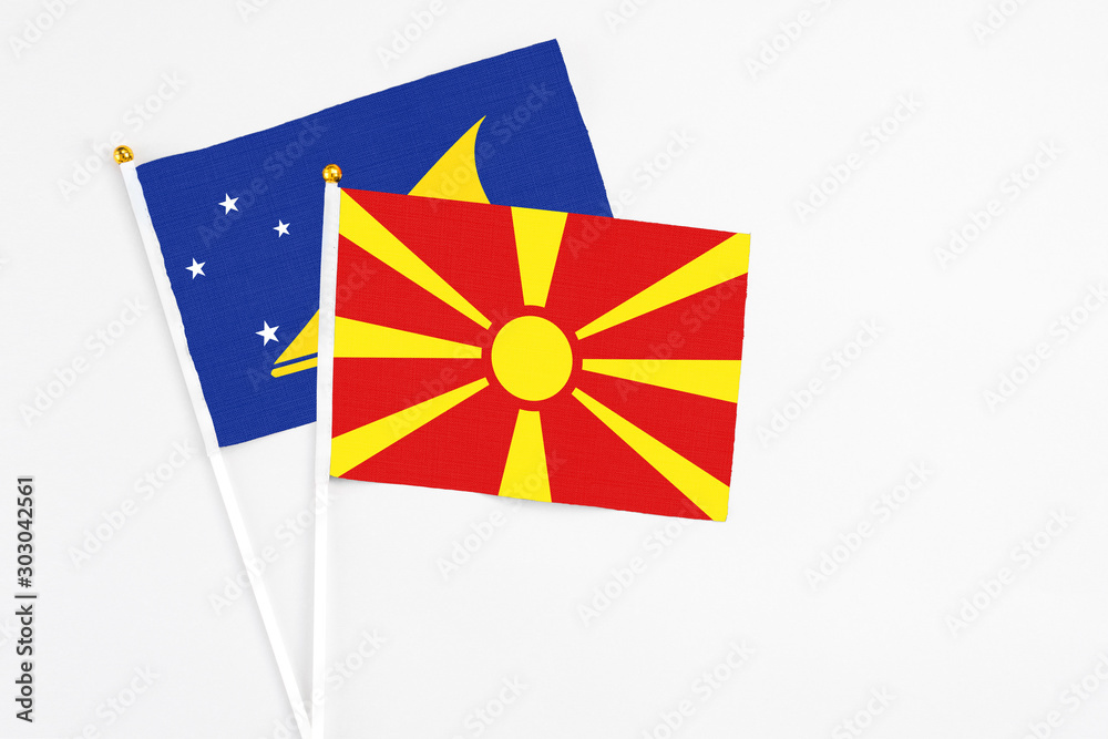 Macedonia and Tokelau stick flags on white background. High quality fabric, miniature national flag. Peaceful global concept.White floor for copy space.
