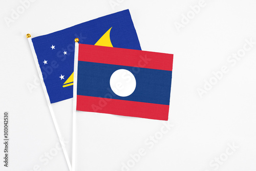 Free Download Laos and Tokelau stick flags on white background. High quality fabric, miniature national flag. Peaceful global concept.White floor for copy space. - GFXLoad