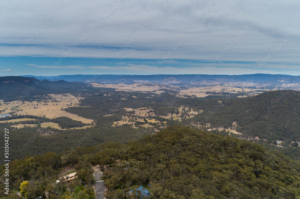 A large valley with green gum trees and blue sky in The Blue Mountains in Australia