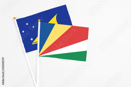 Free Download Seychelles and Tokelau stick flags on white background. High quality fabric, miniature national flag. Peaceful global concept.White floor for copy space. - GFXLoad