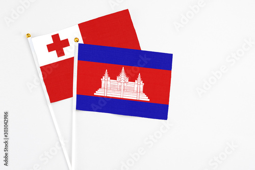 Cambodia and Tonga stick flags on white background. High quality fabric, miniature national flag. Peaceful global concept.White floor for copy space. photo