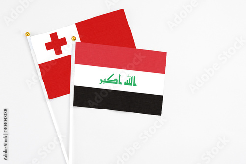 Iraq and Tonga stick flags on white background. High quality fabric, miniature national flag. Peaceful global concept.White floor for copy space.