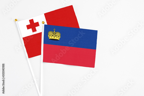 Liechtenstein and Tonga stick flags on white background. High quality fabric, miniature national flag. Peaceful global concept.White floor for copy space. photo