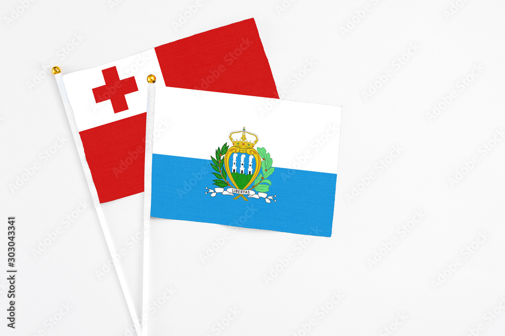 San Marino and Tonga stick flags on white background. High quality fabric, miniature national flag. Peaceful global concept.White floor for copy space. San Marino and Tonga stick flags on white background. High quality fabric, miniature national flag. Peaceful global concept.White floor for copy space.