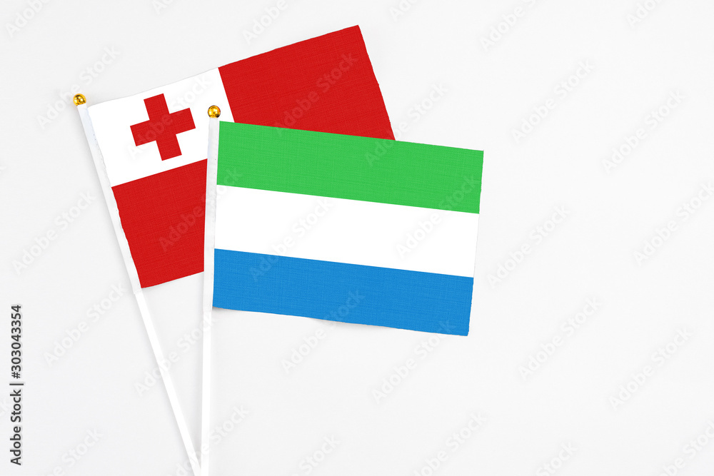 Sierra Leone and Tonga stick flags on white background. High quality fabric, miniature national flag. Peaceful global concept.White floor for copy space. Sierra Leone and Tonga stick flags on white background. High quality fabric, miniature national flag. Peaceful global concept.White floor for copy space.