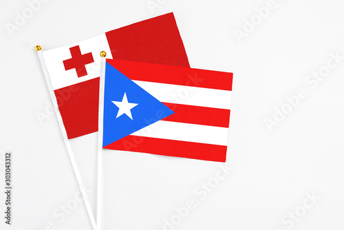 Puerto Rico and Tonga stick flags on white background. High quality fabric, miniature national flag. Peaceful global concept.White floor for copy space. photo