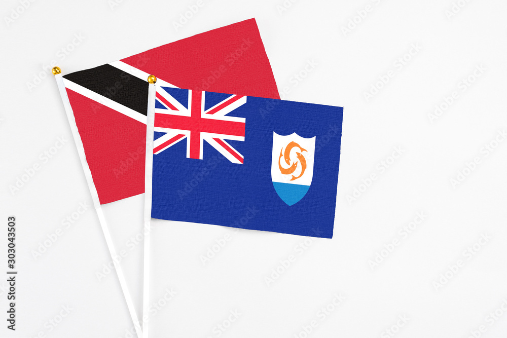 Fototapeta premium Anguilla and Trinidad And Tobago stick flags on white background. High quality fabric, miniature national flag. Peaceful global concept.White floor for copy space.