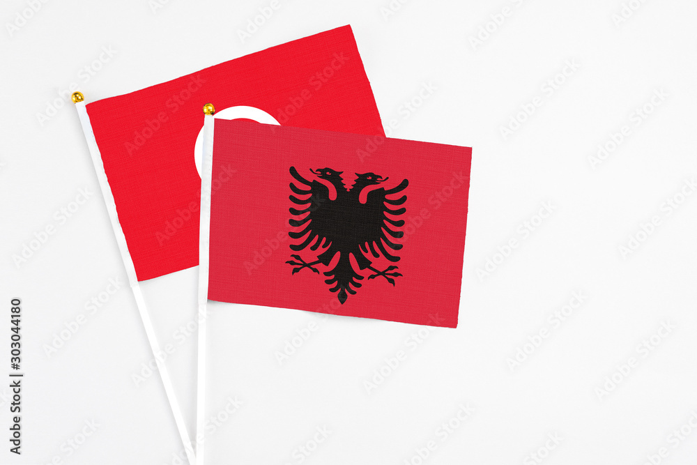 Albania and Tunisia stick flags on white background. High quality fabric, miniature national flag. Peaceful global concept.White floor for copy space. Albania and Tunisia stick flags on white background. High quality fabric, miniature national flag. Peaceful global concept.White floor for copy space.