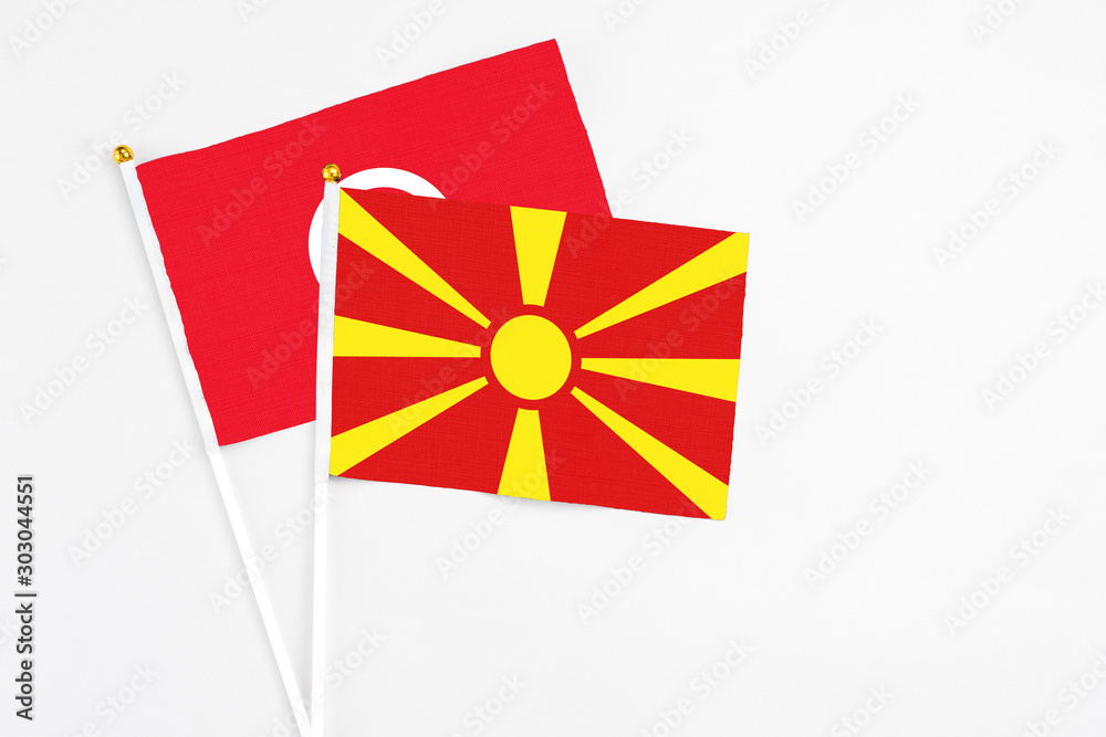 Macedonia and Tunisia stick flags on white background. High quality fabric, miniature national flag. Peaceful global concept.White floor for copy space.