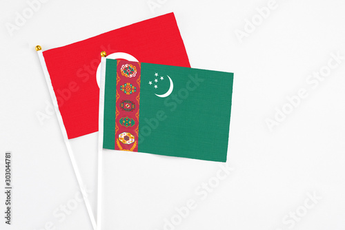 Turkmenistan and Tunisia stick flags on white background. High quality fabric, miniature national flag. Peaceful global concept.White floor for copy space.