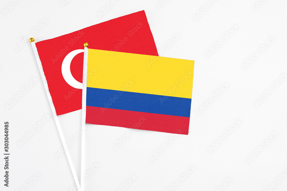 Colombia and Turkey stick flags on white background. High quality fabric, miniature national flag. Peaceful global concept.White floor for copy space. Colombia and Turkey stick flags on white background. High quality fabric, miniature national flag. Peaceful global concept.White floor for copy space.