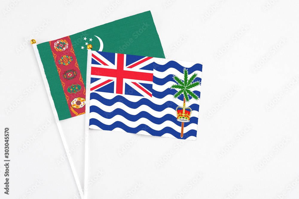 Fototapeta premium British Indian Ocean Territory and Turkmenistan stick flags on white background. High quality fabric, miniature national flag. Peaceful global concept.White floor for copy space.