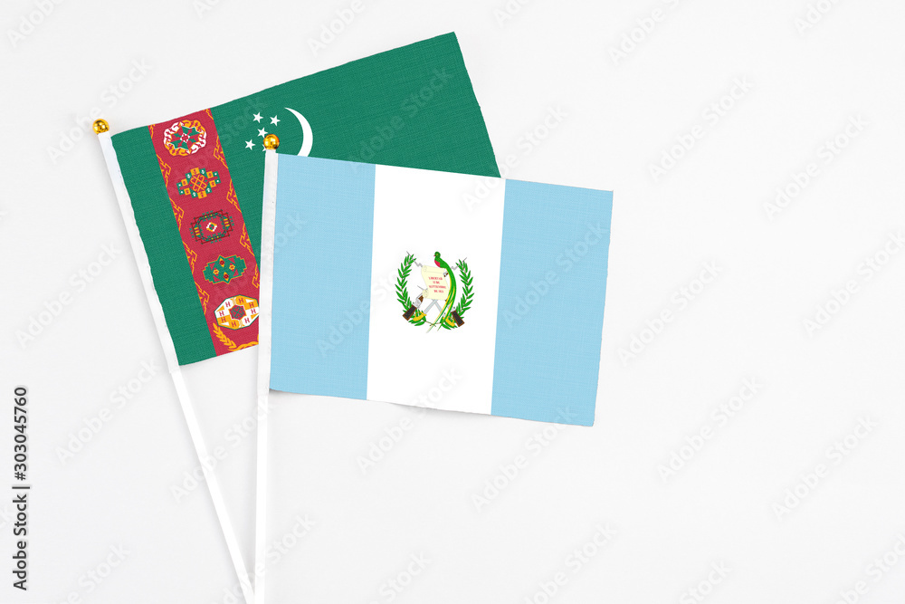Guatemala and Turkmenistan stick flags on white background. High quality fabric, miniature national flag. Peaceful global concept.White floor for copy space. Guatemala and Turkmenistan stick flags on white background. High quality fabric, miniature national flag. Peaceful global concept.White floor for copy space.