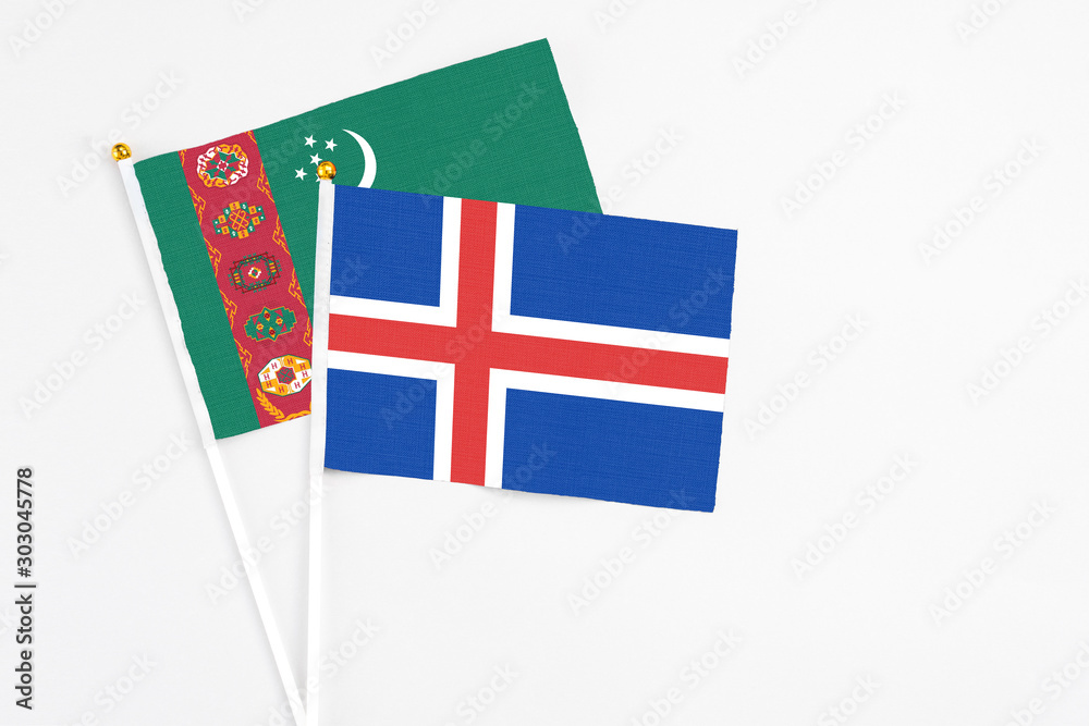 Iceland and Turkmenistan stick flags on white background. High quality fabric, miniature national flag. Peaceful global concept.White floor for copy space.