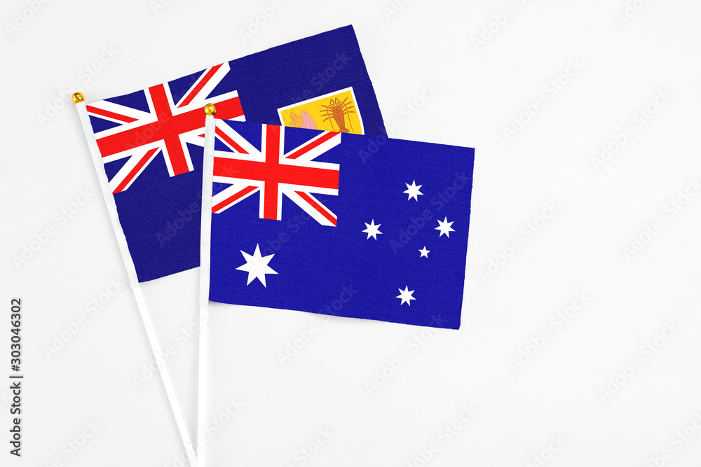 Fototapeta premium Australia and Turks And Caicos Islands stick flags on white background. High quality fabric, miniature national flag. Peaceful global concept.White floor for copy space.