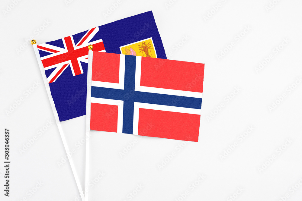 Fototapeta premium Bouvet Islands and Turks And Caicos Islands stick flags on white background. High quality fabric, miniature national flag. Peaceful global concept.White floor for copy space.