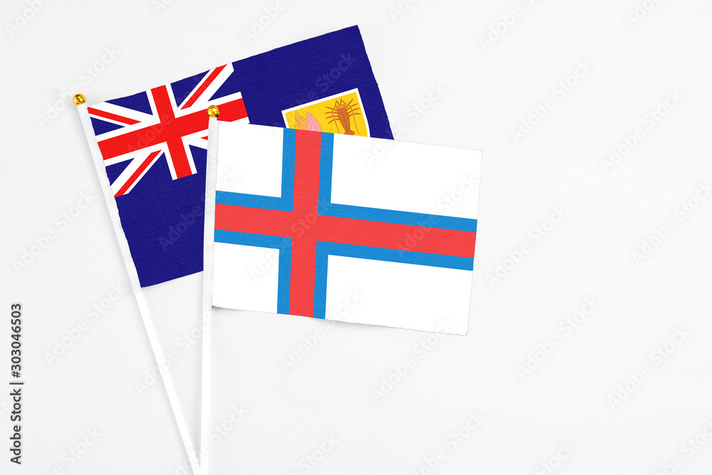 Faroe Islands and Turks And Caicos Islands stick flags on white background. High quality fabric, miniature national flag. Peaceful global concept.White floor for copy space.