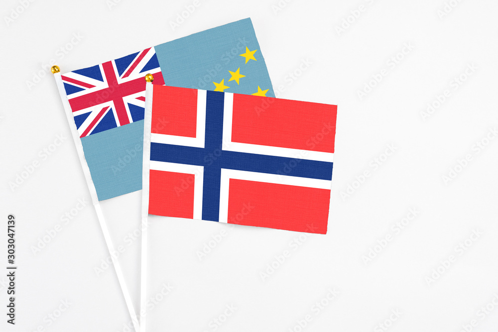 Fototapeta premium Bouvet Islands and Tuvalu stick flags on white background. High quality fabric, miniature national flag. Peaceful global concept.White floor for copy space.