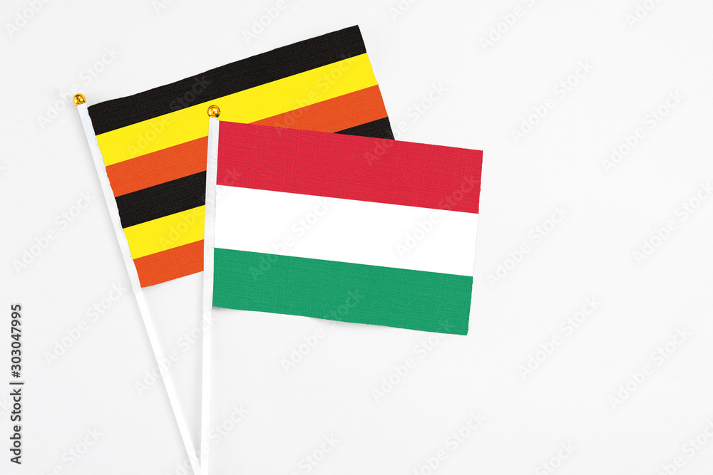 Hungary and Uganda stick flags on white background. High quality fabric, miniature national flag. Peaceful global concept.White floor for copy space. Hungary and Uganda stick flags on white background. High quality fabric, miniature national flag. Peaceful global concept.White floor for copy space.